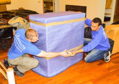 Pictured: professional movers moving a large piece of furniture.